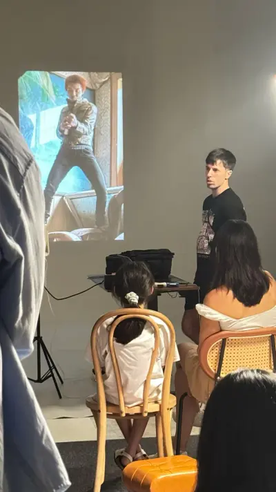 Lemphek speaking beside a projected documentary image at the Guangzhou gathering.
